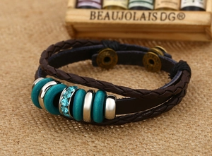 Dettaglio del bracciale multistrato in pelle con anelli turchesi e chiusura a scatto