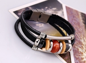 Macro detail of layered leather bracelet with metallic beads and magnetic clasp