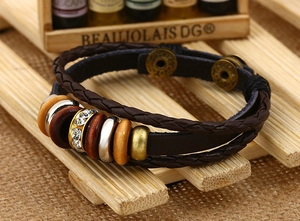 Dettaglio del bracciale multistrato in pelle intrecciata marrone con perline e cristalli