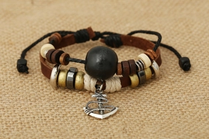 Close-up of multilayer leather bracelet with wooden beads and silver anchor pendant