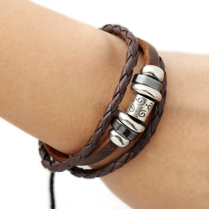 Bracciale multistrato in pelle fatto a mano con perline retrò indossato su sfondo bianco