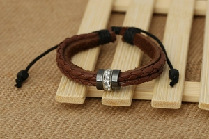Brown braided leather bracelet featuring a crystal-inlaid metal ring and adjustable cord