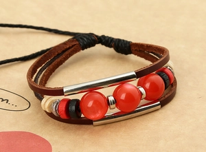 Detailed close-up of multi-layer leather bracelet with red beads and silver accents