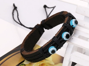 Détail d'un bracelet en cuir vintage avec perles œil bleu et cordon tressé ajustable
