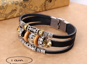 Dettaglio del bracciale multistrato in pelle nera con perle di cristallo e inserti in metallo
