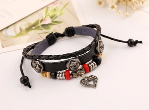 Détail d'un bracelet en cuir multicouche avec perles et pendentif coeur ajouré