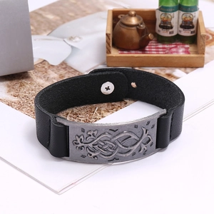 Détail d'un bracelet en cuir vintage avec plaque métallique gravée au motif celtique