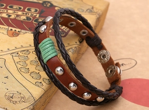 Gros plan sur un bracelet punk en cuir avec clous argentés et fermoir à bouton-pression