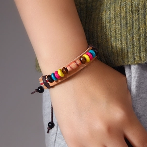 Handmade Bohemian beaded leather bracelet with adjustable cord on model's wrist