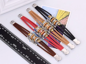 Vista ravvicinata di bracciali multistrato in pelle stile boho con accenti metallici