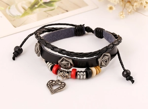 Gros plan sur un bracelet multicouche en cuir vintage avec rose argentée et cœur
