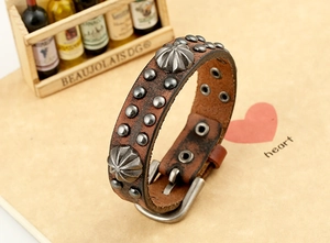 Vue détaillée du bracelet punk en cuir marron avec rivets métalliques et boucle ardillon