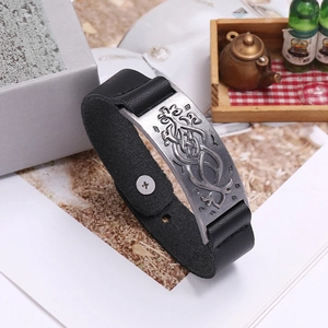 Détail d'un bracelet en cuir de style viking avec plaque gravée de nœuds celtiques