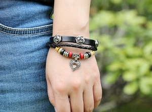 Détail du bracelet multicouche en cuir avec roses en métal, perles et pendentif cœur