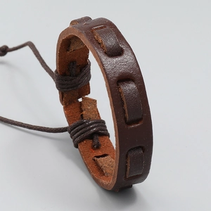 Detail of dark brown vintage braided leather bracelet with ethnic woven textures