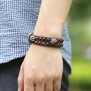 Bracelet punk en cuir marron foncé vintage avec clous en métal porté au poignet