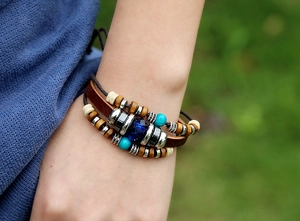 Close-up of bohemian leather bracelet with turquoise beads and wood accents on wrist