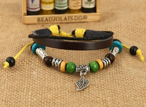 Macro shot of multilayer leather bracelet featuring leaf pendant and colorful wooden beads
