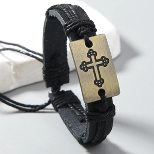 Détail du bracelet en cuir tressé noir avec breloque croix en bronze antique rétro