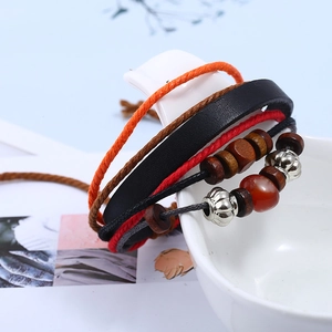 Handmade bohemian multilayer leather bracelet with wooden beads and metal accents on ceramic