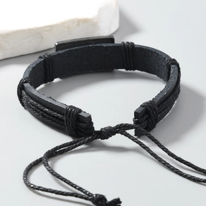 Vue détaillée du bracelet en cuir tressé multicouche avec cordon et plaque en métal