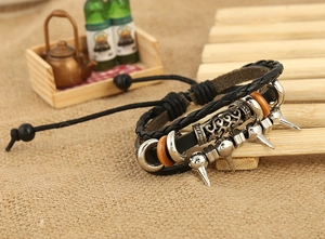 Détail du bracelet en cuir punk avec pointes métalliques et perles vintage sur toile