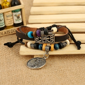 Close-up of beaded leather bracelet with Yin Yang charm on rustic burlap background