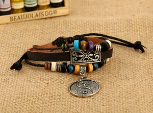 Multilayer leather bracelet with wood beads and yin yang pendant on burlap background