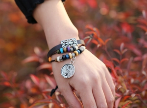 Close-up of multilayer leather bracelet with colorful beads and silver Yin Yang pendant
