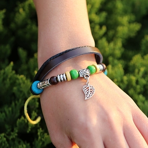 Bohemian multilayer leather bracelet with wooden beads and silver leaf pendant on wrist