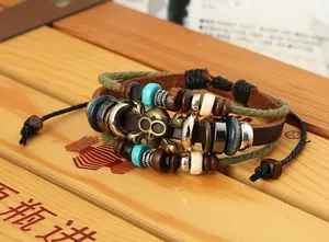 Dettaglio del bracciale multistrato in pelle con teschio in metallo e perline di legno