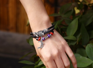 Detail of bohemian multilayer leather bracelet with silver moon charm and colorful beads