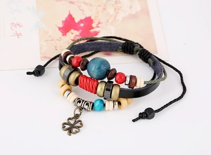 Detail of multilayer leather bracelet featuring colorful beads and a clover leaf pendant