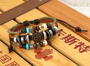 Dettaglio del bracciale in pelle multistrato con ingranaggio in bronzo e perle