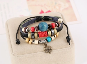 Macro shot of multilayer leather bracelet with colorful wood beads and clover charm