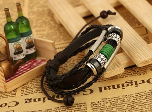 Detail of vintage multilayer braided leather bracelet with beads on a wooden stand