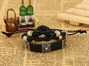 Detail view of retro punk leather bracelet set with woven cord and metallic charms