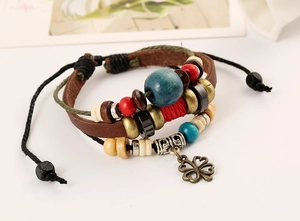 Macro shot of multilayer leather bracelet featuring clover charm and colorful beads