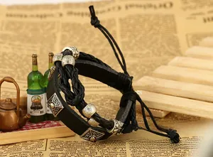 Detail view of multi-layer punk leather bracelet with vintage bronze charms and braided cords