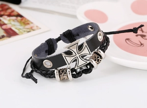 Détail d'un bracelet en cuir tressé avec croix de fer argentée et perles vintage