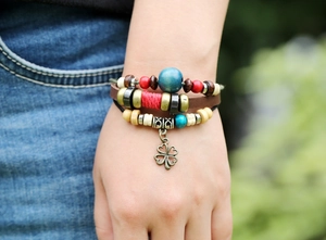 Detail of multilayer leather bracelet with colorful beads and vintage clover charm