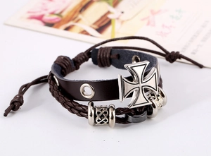 Détail d'un bracelet vintage en cuir multicouche avec breloque croix de fer et cordons