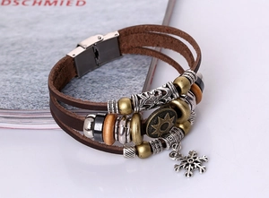 Detail of multi-layer brown leather bracelet with wood beads and silver snowflake charm