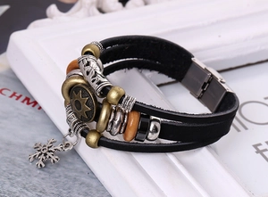 Detail of multi-layer leather bracelet with vintage beads and snowflake charm pendant