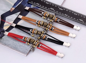 Detail view of multi-layer leather bracelets with sun pattern charms and snowflake pendants