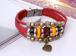 Detail of red leather woven bracelet featuring multi-color beads and a heart rose charm