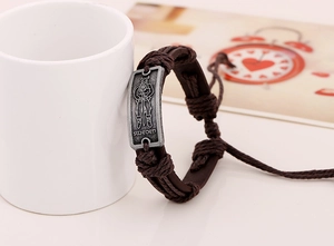 Detail of vintage brown braided leather bracelet with Sweden Viking metal plate