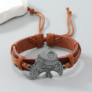 Detail of vintage braided leather bracelet with silver fish pendant and adjustable cord