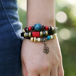 Bohemian multilayer leather beaded bracelet with a bronze clover charm on a model's wrist