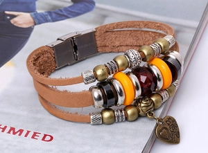 Detail of multi-layer brown leather bracelet with ethnic beads and heart charm